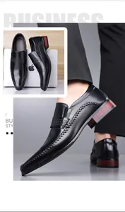 Close-up of black leather business shoes with decorative stitching and wood-grain heels