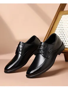 Détail de chaussures habillées noires pour hommes avec lacets et ornement en V argenté