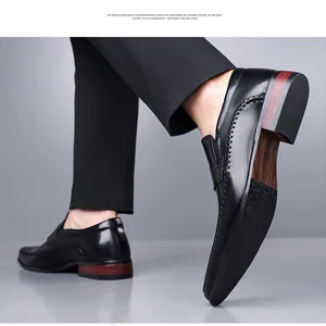 Detail of black leather loafers showing red-brown wood grain heel and anti-slip sole