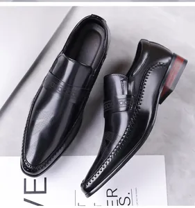 Detailed view of black pointed toe business loafers with brogue perforations and side stitching