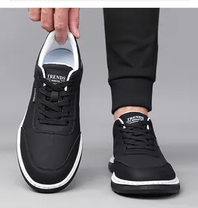 Detail of black leather sneakers with white soles showing perforated texture and fashion logo