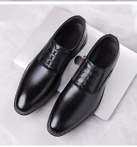 Detailed view of black leather oxford dress shoes with stitching on a silver laptop