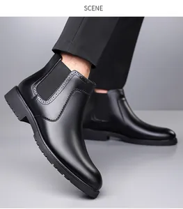 Λεπτομέρεια από μαύρα ανδρικά μποτάκια Chelsea με brogue σχέδια και χοντρή σόλα