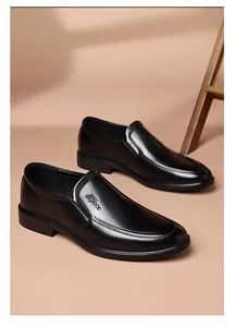Detailed close-up of black slip-on leather shoes with sport emblem and side stitching