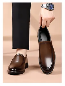 Detail of dark brown leather loafers showing smooth texture and side logo embossing