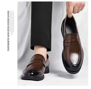 Primer plano de mocasines Penny de cuero marrón oscuro pulido con punta degradada y suela