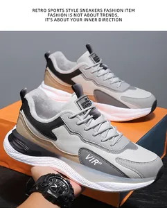 Nahaufnahme grauer Retro-Sneaker mit Leder-Stitching auf einer orangefarbenen Box