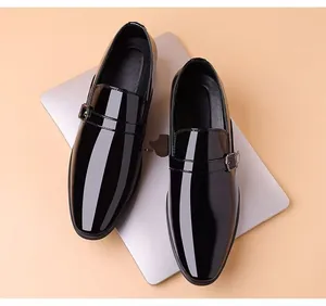 Detalle de zapatos monk de charol negro con una elegante hebilla metálica