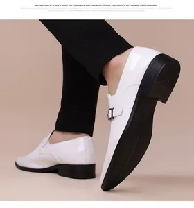 Detalle de mocasines de charol blanco con hebilla de metal y suela negra de hombre