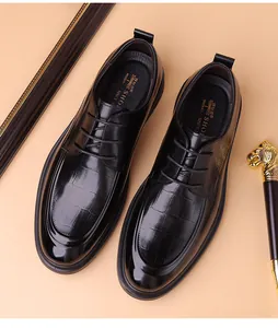 Macro view of men's black derby shoes showing crocodile embossed leather and wax laces