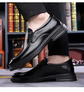 Detail of black leather loafers with brogue perforations and thick rubber soles