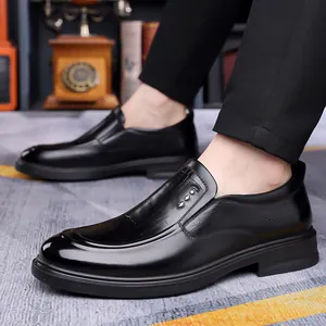 Men's black leather loafers with crocodile texture and metal buckle on office carpet