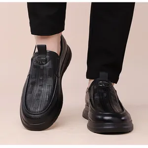 Detailed view of black leather loafers featuring textured patterns and metal buckle