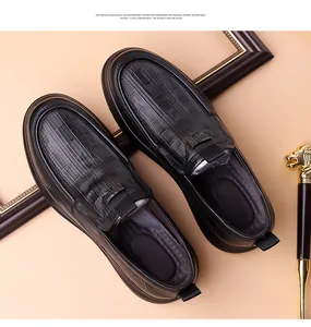 Close-up of black crocodile pattern leather loafers with metallic buckle decoration