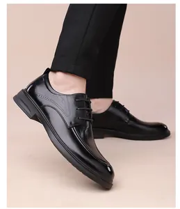 Detail of men's black derby shoes showing crocodile texture and side stitching details