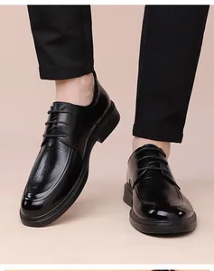 Detail of men's black derby shoe featuring embossed crocodile leather texture and laces