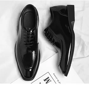 Detail of black glossy leather derby shoes with brogue perforations and lace-up design