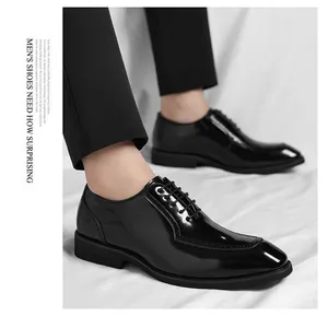 Detail view of black glossy patent leather men's dress shoes with stylish U-stitch toe design