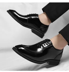 Close-up of black patent leather dress shoes with glossy finish and lace-up closure detail