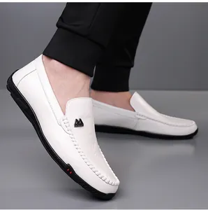 Detailed view of men's white leather loafers with black M buckle and hand-stitched seams