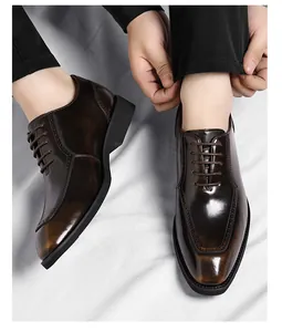 Close-up of brown polished leather shoes with geometric stitching and classic lacing