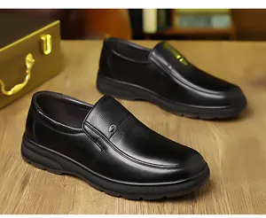 Dettaglio scarpe business in pelle nera con trama a grana su un tavolo di legno
