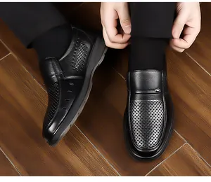 Dettaglio scarpe da ufficio in pelle nera con traforatura laser su pavimento scuro