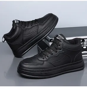 Dettaglio di sneakers alte in ecopelle nera appoggiate su una valigetta in metallo argento