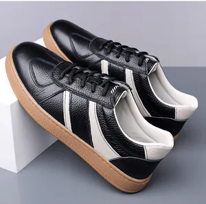 Detail of men's leather sneakers with black pebbled texture and gum rubber sole