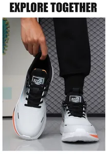 Detail of grey gradient running shoes with black laces and vibrant orange accents on the sole