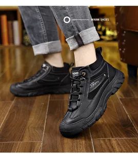 On-foot view of black thermal fleece-lined leather boots for men in a cozy indoor setting