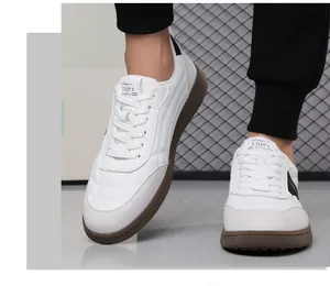 Detail of white fashion sneakers with tan rubber soles and contrast leather stitching