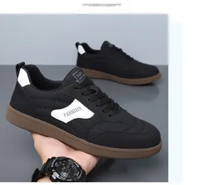 Detailed close-up of fashion casual black sneakers with brown rubber soles and leather patches