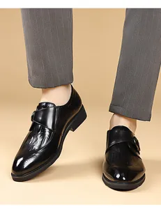 Dettaglio di scarpe monk nere in pelle con motivi Brogue e goffratura a coccodrillo