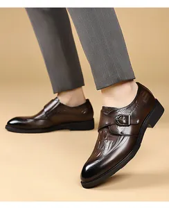 Dettaglio di scarpe monk in pelle marrone con motivo coccodrillo e fibbia in metallo