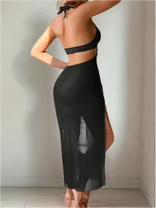 Détail d'une robe noire dos nu en maille transparente avec fente haute et licou au cou