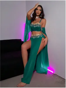 Détail du crop top en satin vert émeraude avec franges dorées et jupe fendue assortie