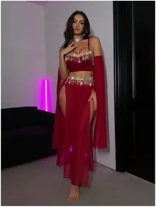 Détail de la lingerie en velours rouge vin avec franges dorées et fentes latérales hautes