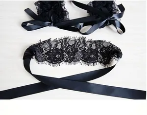 Sexy black lace eye mask and ribbon handcuff set for women on light wooden background