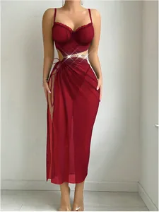 Detail of dark red sheer mesh maxi dress with waist cut-outs and gold chain accents