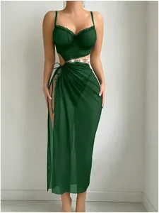 Detail of dark green mesh dress with gold chain belt and high side slit design
