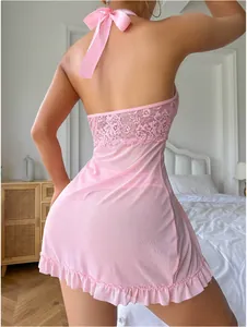Détail du dos d'une nuisette rose en dentelle avec un grand nœud en satin et un dos nu