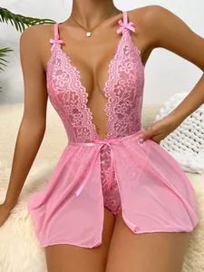 Sexy pink lace bodysuit with deep V-neck and mesh details on a soft home sofa