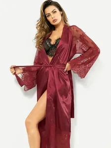 Détail du peignoir en satin bordeaux avec dentelle délicate aux manches et à l'ourlet