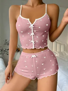 Close-up of pink heart print lingerie set with white lace trim and bow detailing