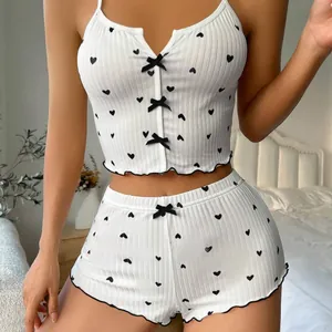 White two-piece lingerie set with heart print, black bows, and ruffled trim for sleepwear