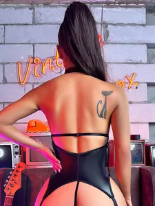 Body sexy en similicuir noir dos nu avec coupe string haute dans un décor de style industriel