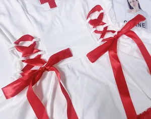 Detail of white nurse costume with red cross patch and satin ribbon lacing design