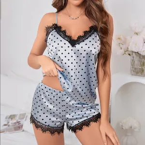 Détail d'un pyjama en satin bleu clair à pois avec bordure en dentelle noire