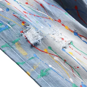 Distressed light blue denim shorts with colorful paint splatter and ripped details